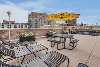 an outdoor patio with tables and chairs and an umbrella on a roof